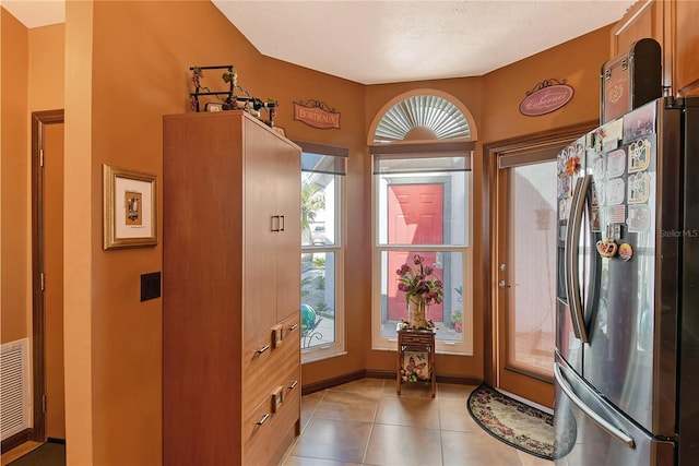 doorway featuring light tile patterned floors and a healthy amount of sunlight