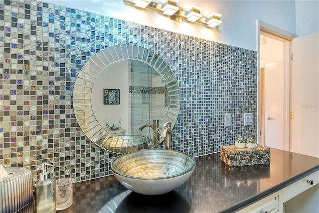 bathroom with decorative backsplash, sink, and tile walls