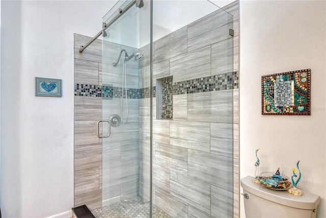 bathroom featuring an enclosed shower and toilet