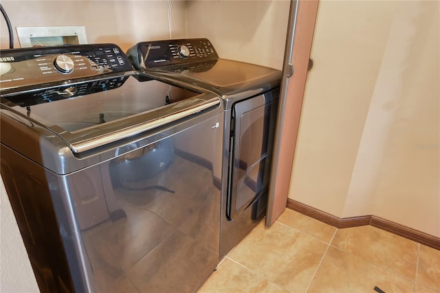 clothes washing area featuring light tile patterned floors and independent washer and dryer