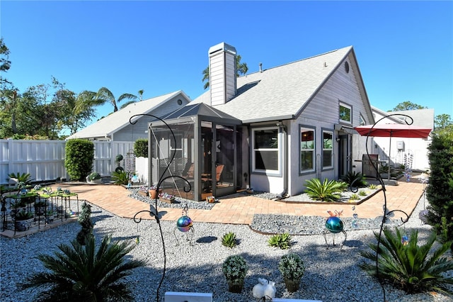 rear view of property with a sunroom and a patio