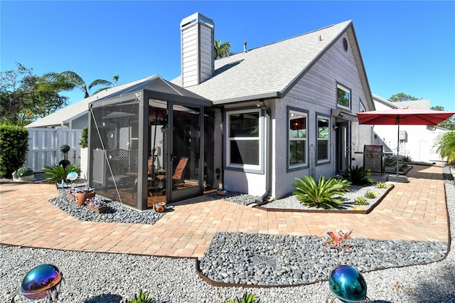 rear view of property featuring a patio and a sunroom