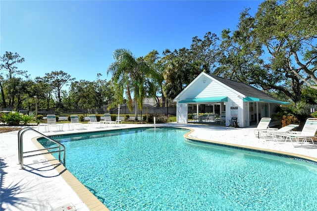 view of pool with an outbuilding and a patio