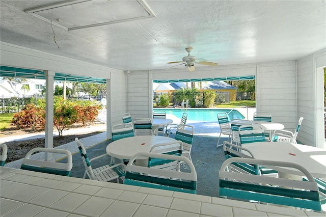 view of swimming pool featuring ceiling fan and a patio area