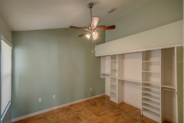 7806 Ontario Street Cir Unit 7806, Sarasota, FL 34243 - unfurnished bedroom with lofted ceiling, dark tile patterned floors, ceiling fan, and baseboards