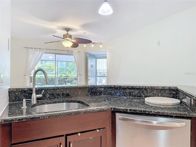 kitchen with ceiling fan, dishwasher, dark stone counters, and sink