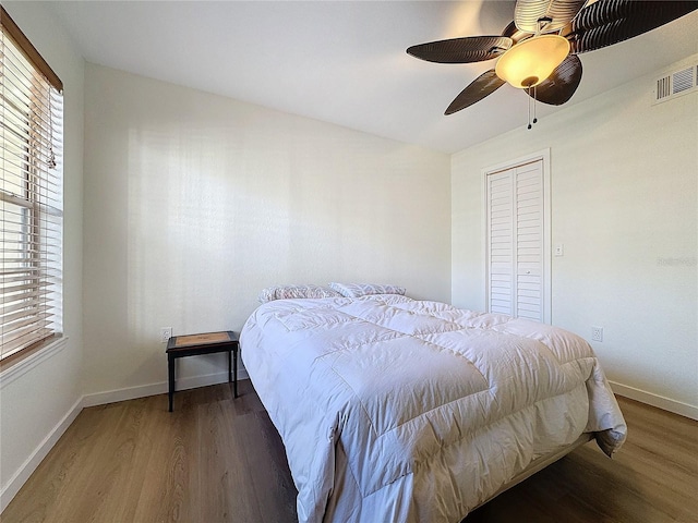 bedroom with a closet, ceiling fan, and dark wood-type flooring