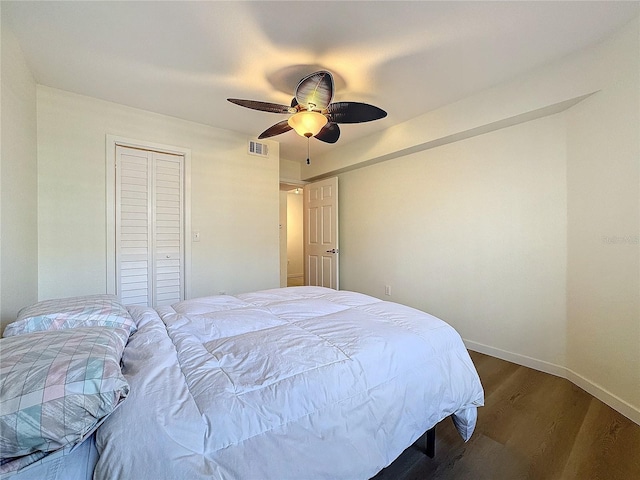 bedroom featuring ceiling fan, dark hardwood / wood-style floors, and a closet