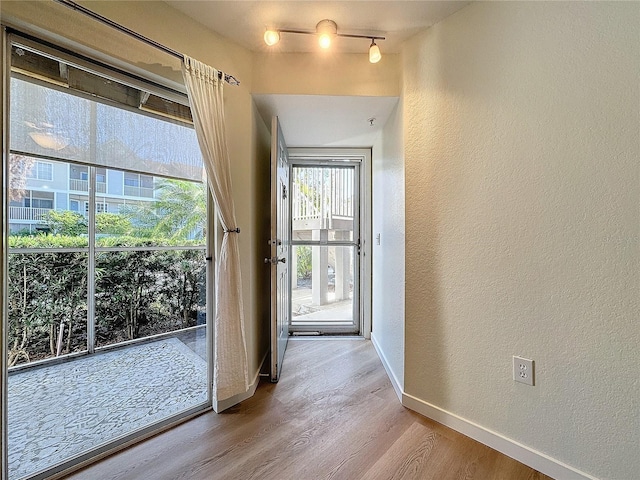 doorway to outside featuring light hardwood / wood-style floors and track lighting