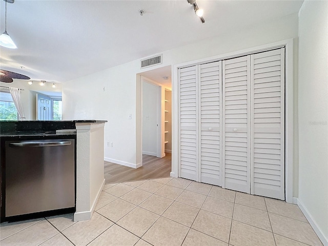 kitchen with dishwasher, light tile patterned floors, track lighting, and decorative light fixtures