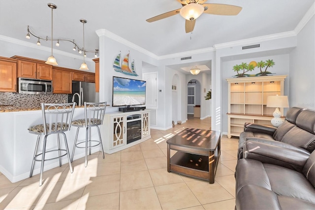 tiled living room featuring ceiling fan and ornamental molding