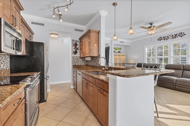 500 San Lino Cir Unit 511, Venice, FL 34292 - kitchen featuring appliances with stainless steel finishes, a breakfast bar, backsplash, light tile patterned flooring, and crown molding