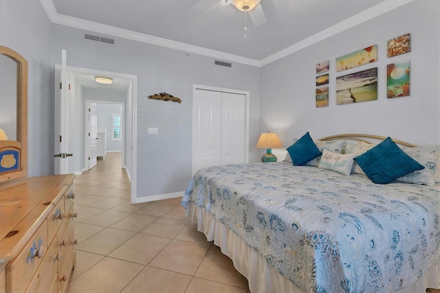 bedroom featuring light tile patterned floors, a closet, ceiling fan, and crown molding