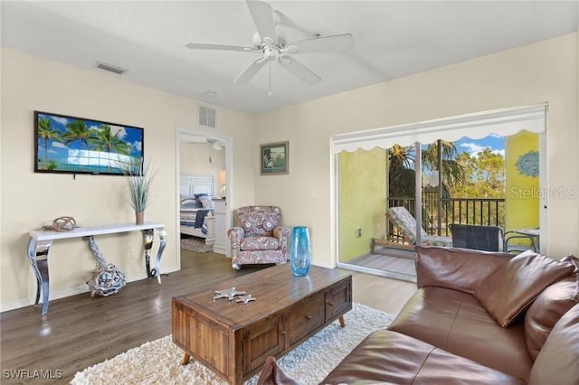 living room featuring ceiling fan and dark wood-type flooring