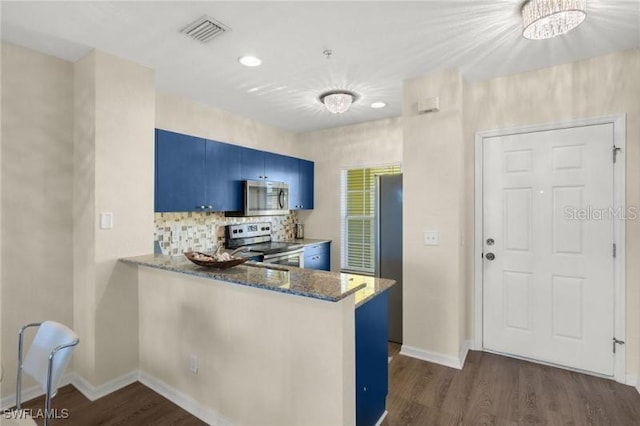 2060 Willow Hammock Cir Unit 304, Punta Gorda, FL 33983 - kitchen featuring stainless steel appliances, blue cabinetry, dark wood finished floors, stone countertops, and backsplash