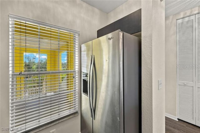 kitchen featuring stainless steel fridge and dark hardwood / wood-style flooring