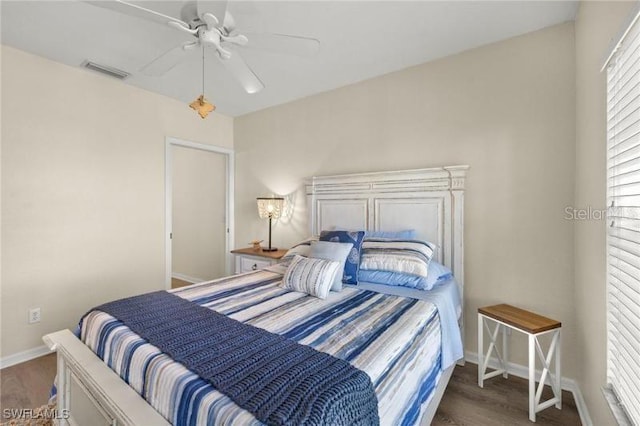 bedroom with dark hardwood / wood-style flooring and ceiling fan