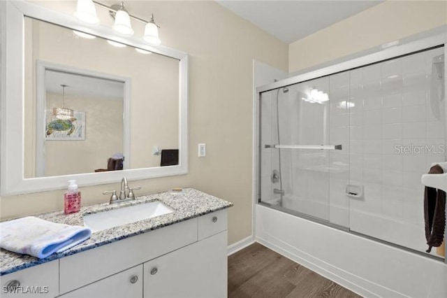 bathroom with vanity, hardwood / wood-style flooring, and enclosed tub / shower combo