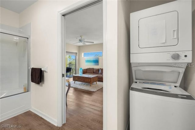 washroom featuring ceiling fan, dark hardwood / wood-style floors, and stacked washer / drying machine