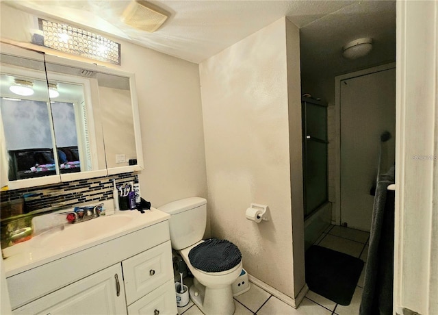 bathroom with tasteful backsplash, tile patterned floors, an enclosed shower, vanity, and toilet