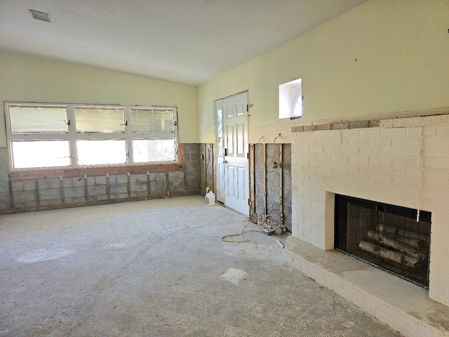 interior space with a fireplace, plenty of natural light, and lofted ceiling