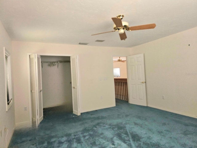 unfurnished bedroom with dark colored carpet, a closet, and ceiling fan