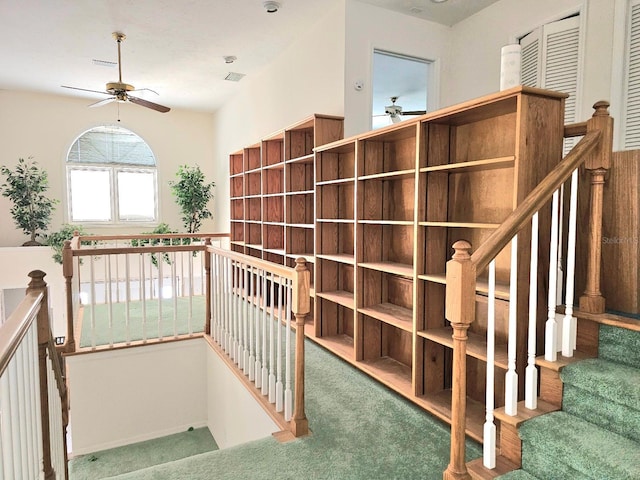 stairs featuring carpet flooring and ceiling fan