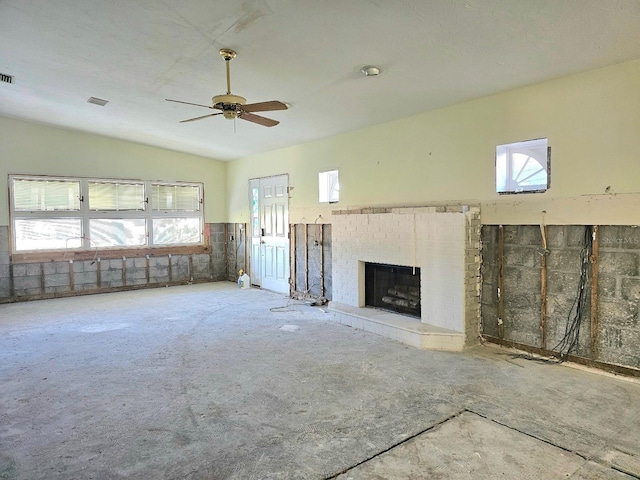 unfurnished living room featuring a fireplace, ceiling fan, and lofted ceiling