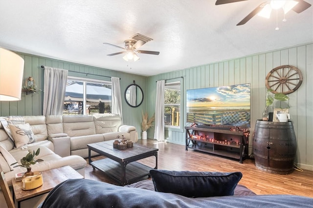 living room with hardwood / wood-style floors, plenty of natural light, and a textured ceiling