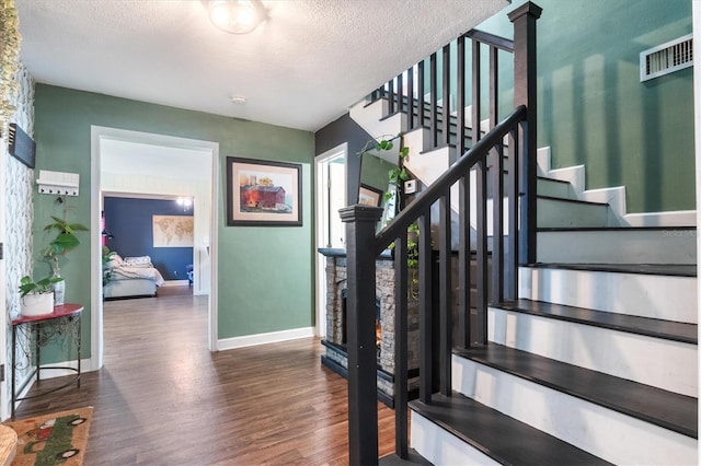 stairway featuring hardwood / wood-style floors and a textured ceiling