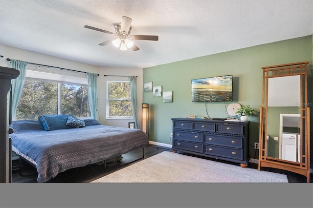 bedroom featuring ceiling fan, light hardwood / wood-style flooring, and a textured ceiling