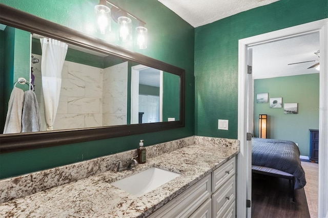 bathroom with a shower with curtain, vanity, hardwood / wood-style flooring, and ceiling fan