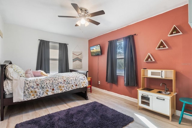 bedroom with light hardwood / wood-style flooring and ceiling fan