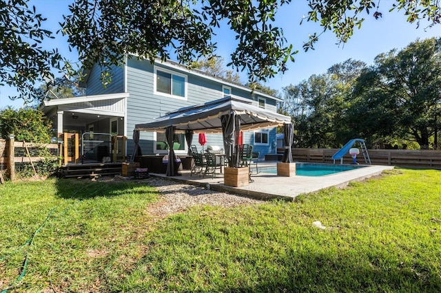 back of house featuring a yard, a patio, and a fenced in pool