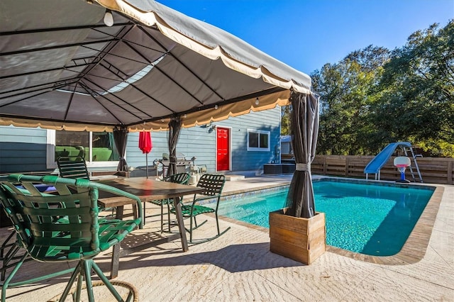 view of swimming pool with a patio and a water slide