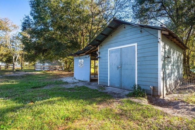 view of outdoor structure featuring a lawn