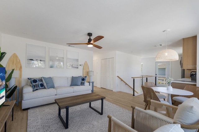 living room featuring ceiling fan and light hardwood / wood-style floors