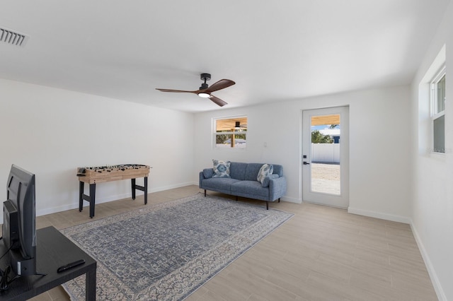 living room with ceiling fan and light hardwood / wood-style flooring