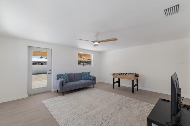 living room with light wood-type flooring and ceiling fan