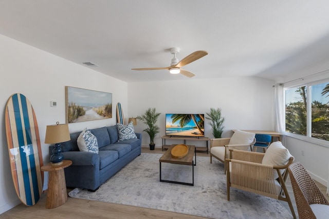 living room with light wood-type flooring, vaulted ceiling, and ceiling fan