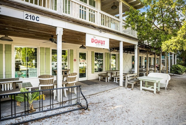 view of patio with ceiling fan and a balcony