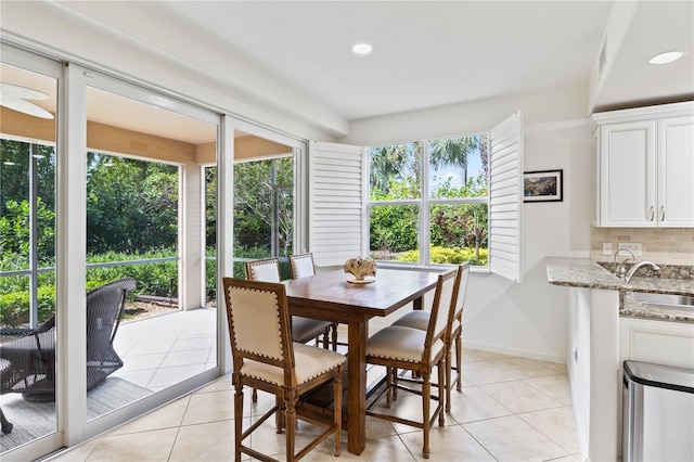 dining space featuring light tile patterned floors, plenty of natural light, and sink