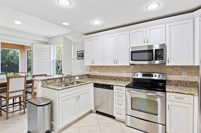 kitchen featuring appliances with stainless steel finishes, white cabinetry, and sink