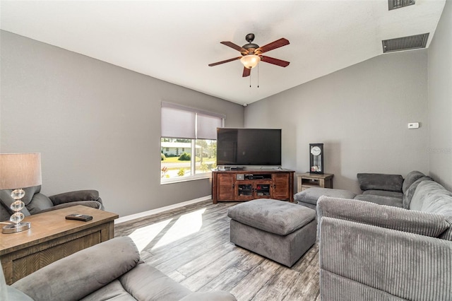 living room with light hardwood / wood-style flooring, vaulted ceiling, and ceiling fan