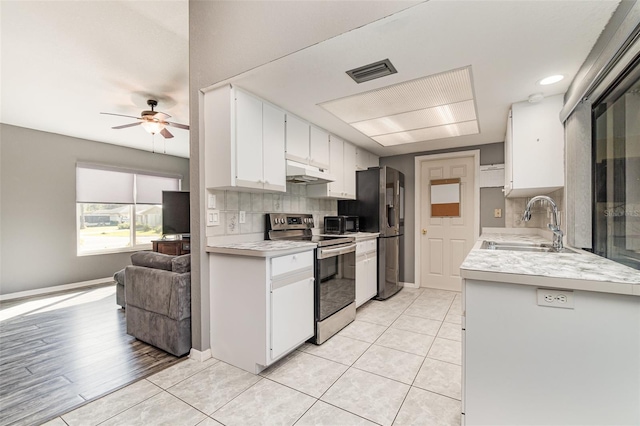 kitchen featuring decorative backsplash, appliances with stainless steel finishes, ceiling fan, sink, and white cabinetry