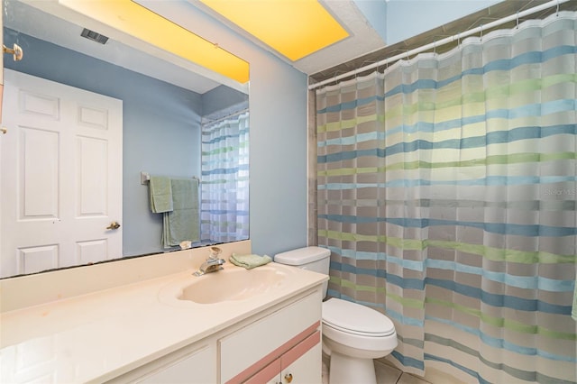 bathroom featuring tile patterned flooring, vanity, and toilet