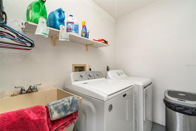 clothes washing area featuring independent washer and dryer and sink