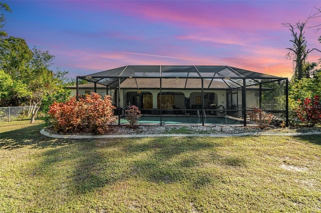 exterior space featuring glass enclosure and a lawn