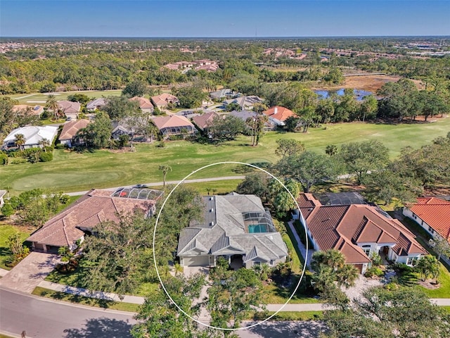 drone / aerial view with view of golf course, a water view, and a residential view