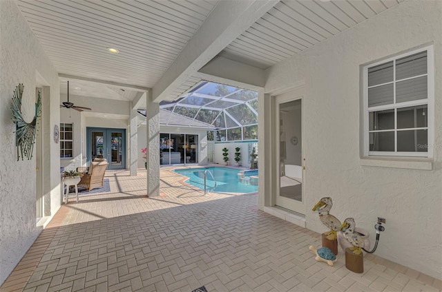 view of pool with glass enclosure, french doors, and a patio